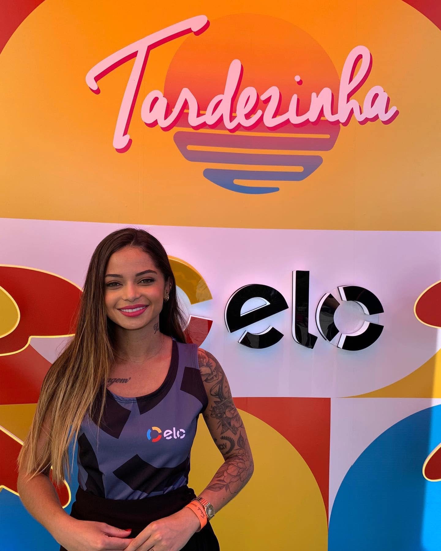 Bárbara Macedo diante do painel Elo no evento Tardezinha