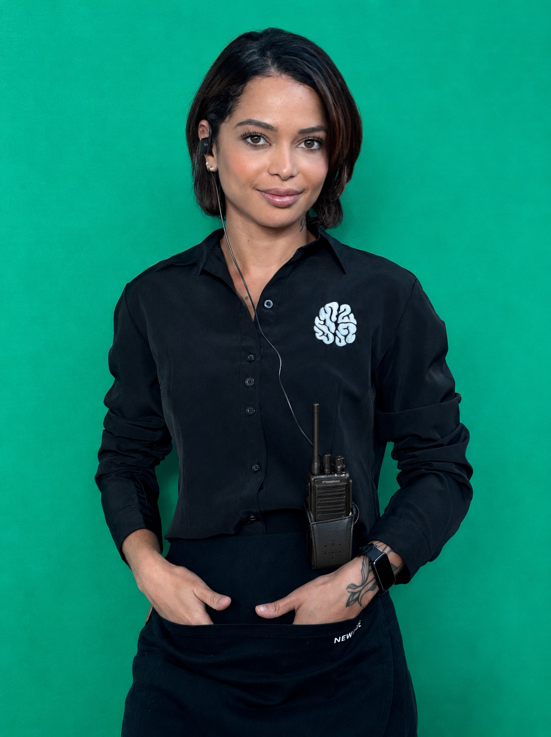Bárbara Macedo de uniforme e rádio comunicador em trabalho de produção